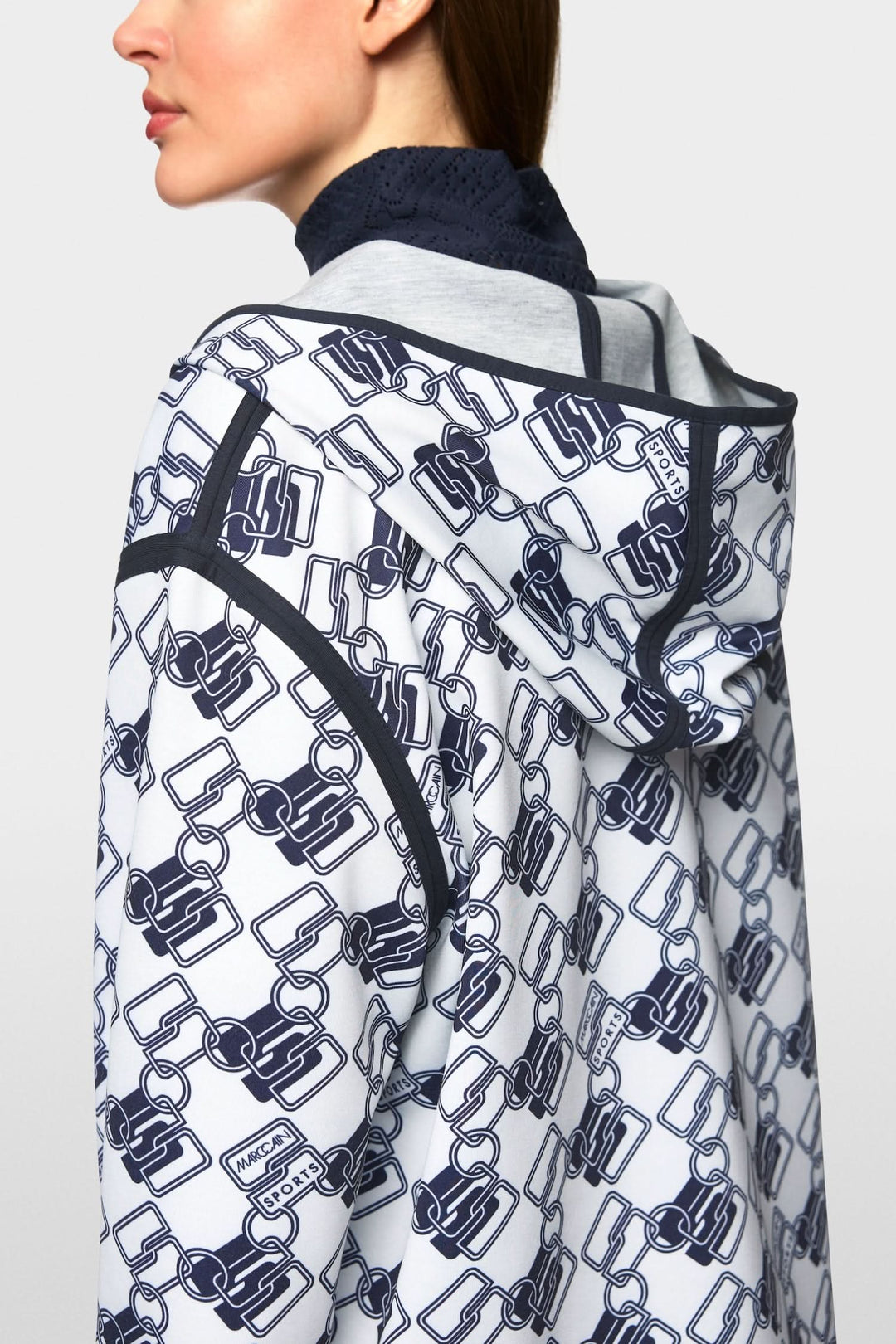 Chandail à capuche réversible avec motif géométrique moderne vue de dos, fentes latérales et capuche.