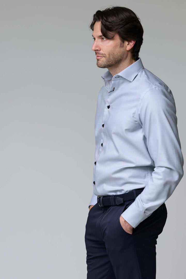 Homme portant une chemise à micro-motif texturé avec manches longues, idéale pour le bureau ou une occasion chic, style élégant et ajusté.