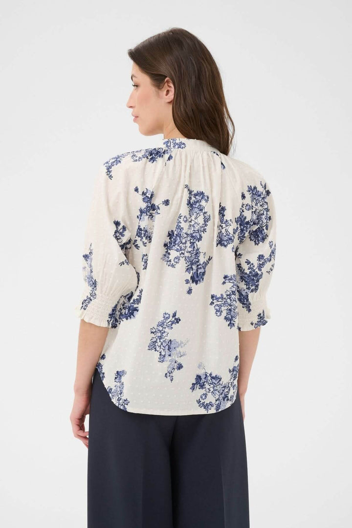 Blouse à imprimé floral Almeras avec manches bouffantes et col montant, vue de dos sur mannequin. Élégante et raffinée, en tissu fluide.