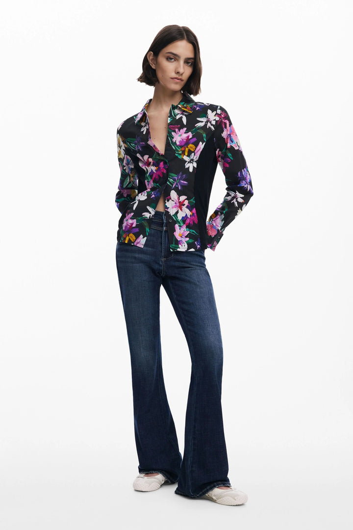 Chemise à fleurs avec col classique, manches longues, portée avec un jean, look féminin et décontracté.