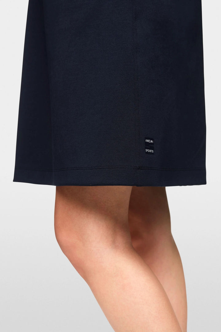 Détail d'une robe courte navy avec étiquette, affichant une silhouette élégante et sportive.