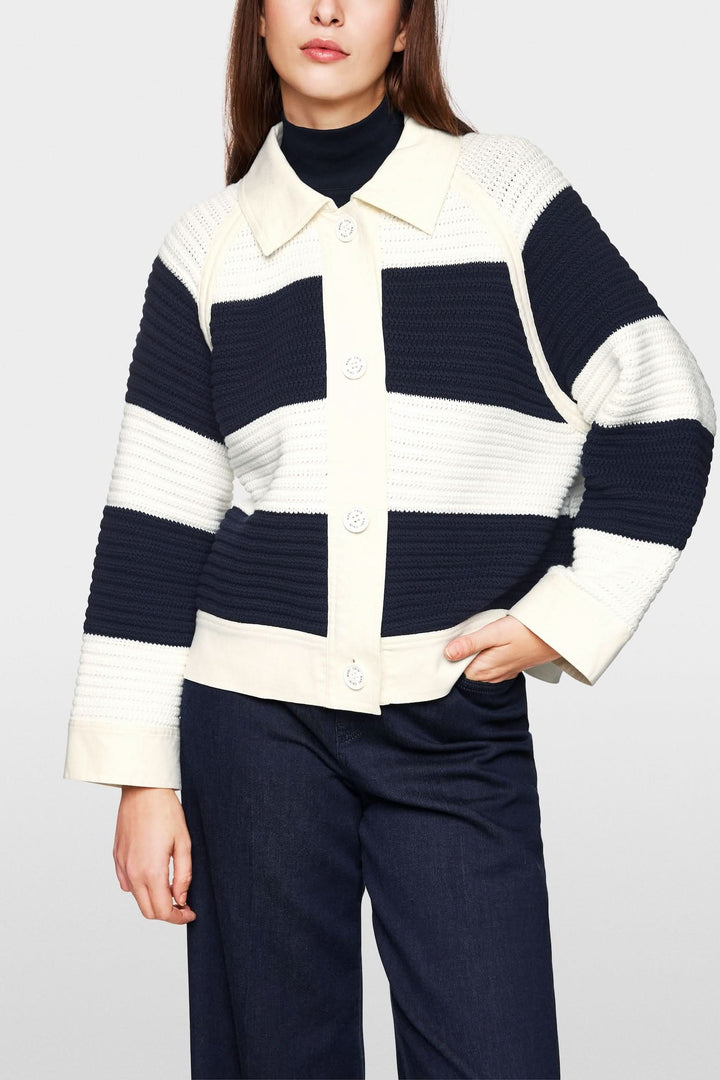 Cardigan court à blocs de couleur en maille, ample avec empiècements en denim, look décontracté et moderne.