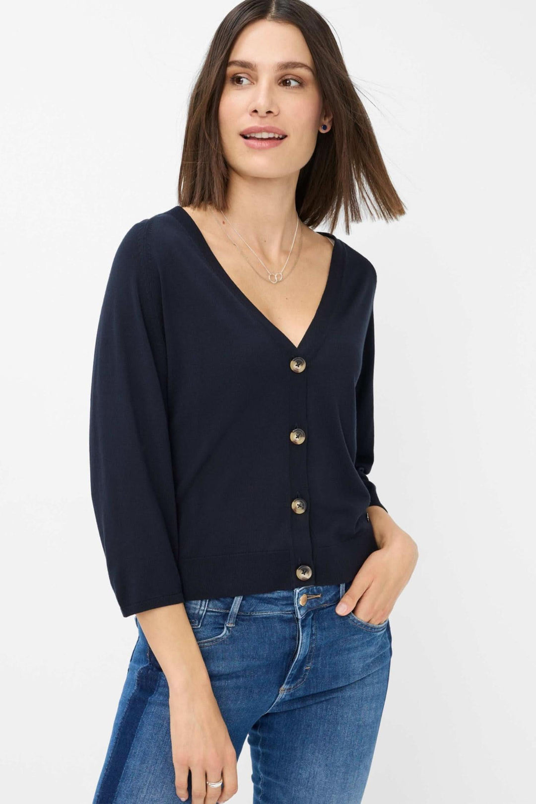 Cardigan Anique navy bleu avec encolure V profonde et patte de boutonnage, porté avec jean ajusté.