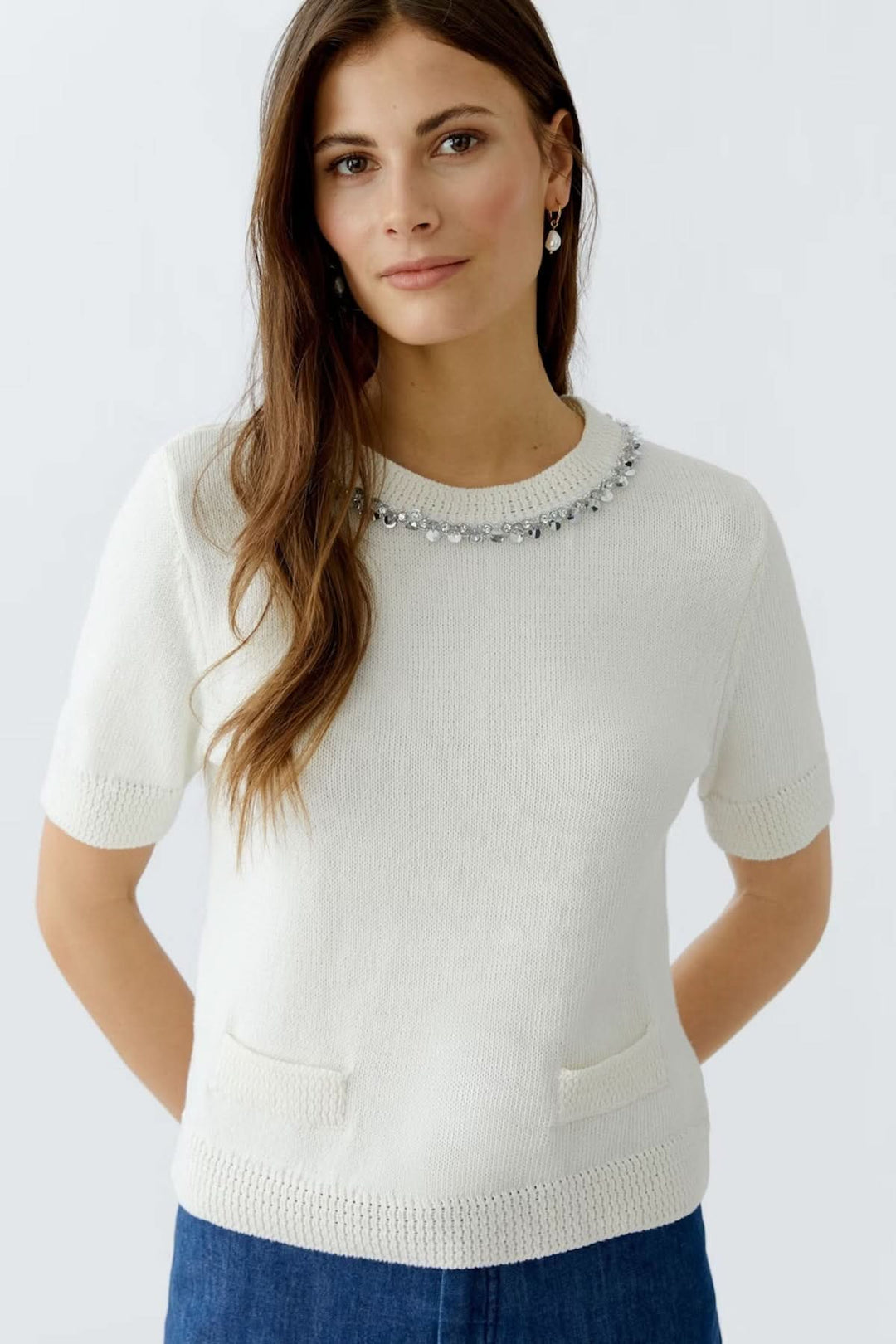 Chandail à col décoré, à manches courtes, en maille douce avec encolure ornée de perles et petites poches, couleur blanche.
