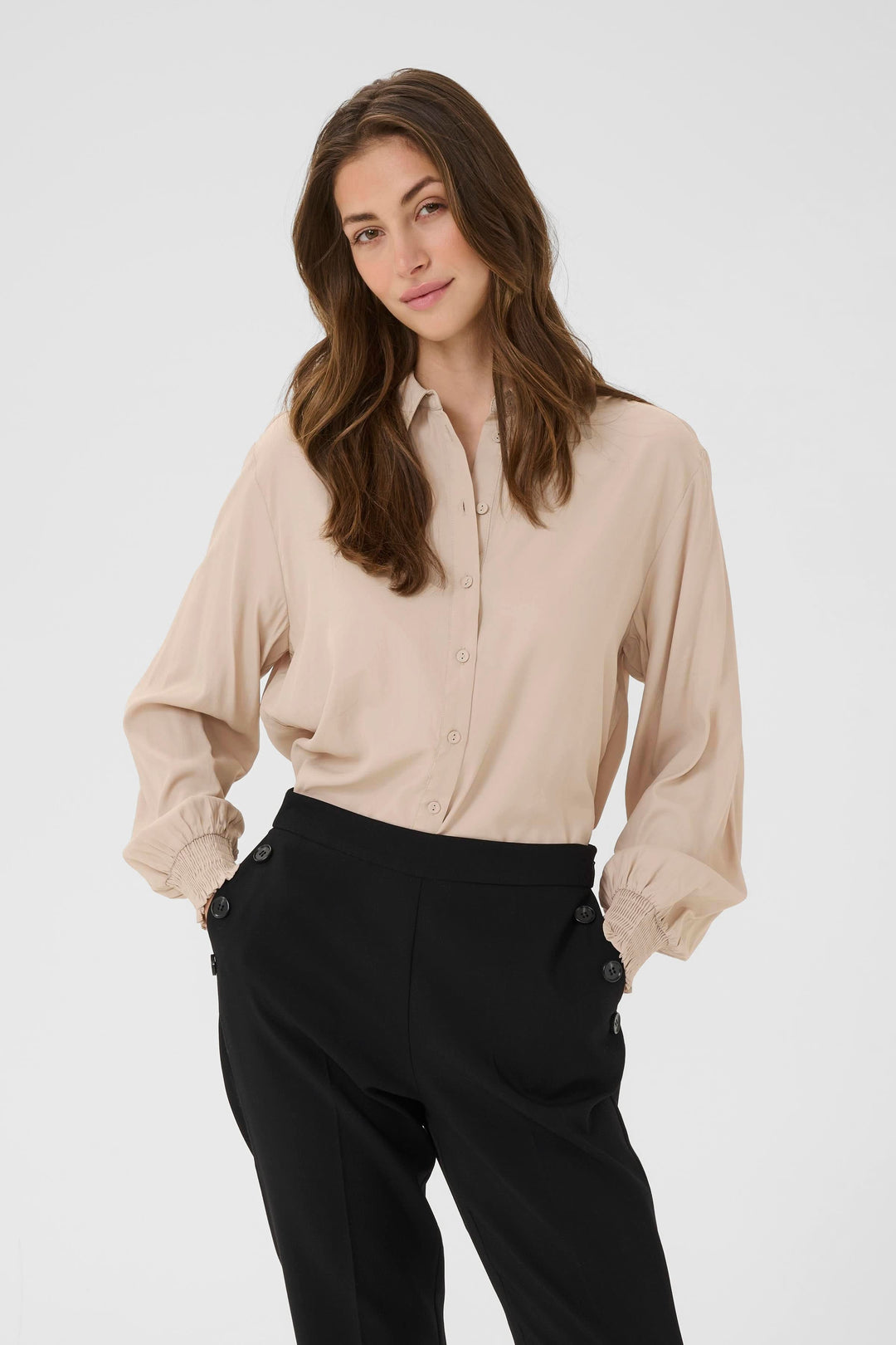 Modèle portant la Blouse Nola fluide à poignets smockés, élégante et décontractée, adaptée pour le travail ou le week-end.