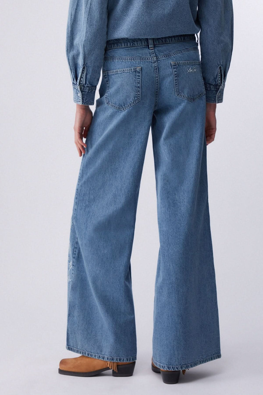 Jean à jambe large imprimé, denim souple, vue arrière, coupe fluide, confort optimal pour une silhouette allongée.