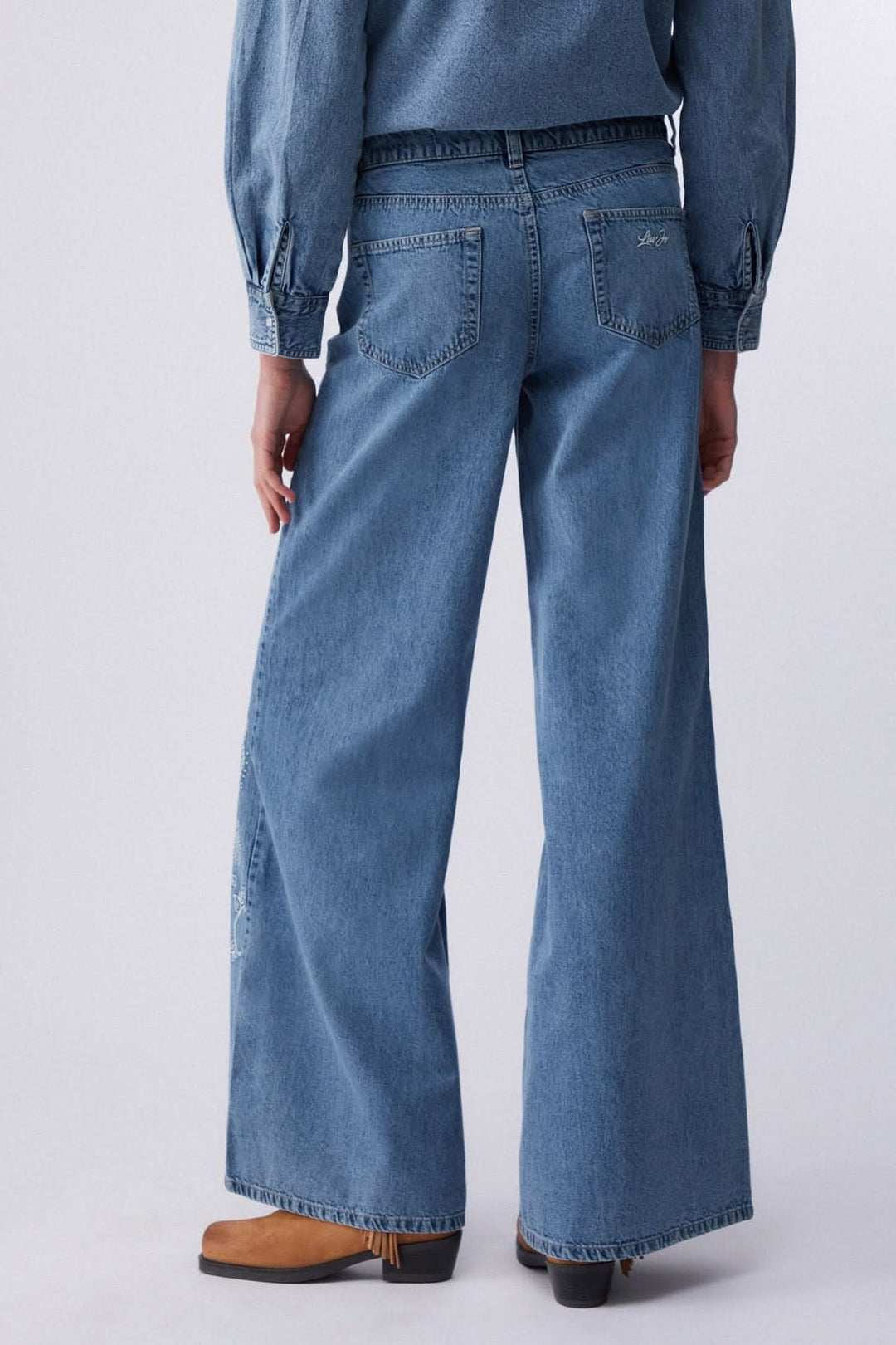 Jean à jambe large imprimé, denim souple, vue arrière, coupe fluide, confort optimal pour une silhouette allongée.