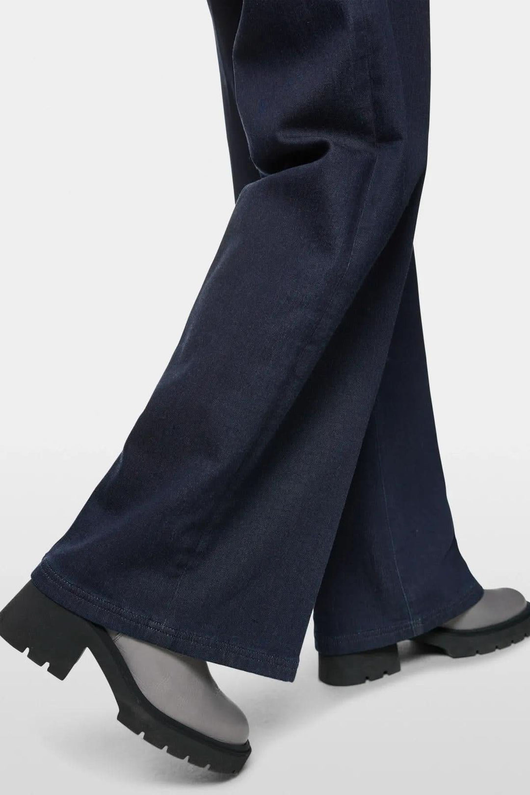 Jean évasé WELKOM en coton biologique, avec des chaussures à semelle épaisse, offrant une silhouette moderne.