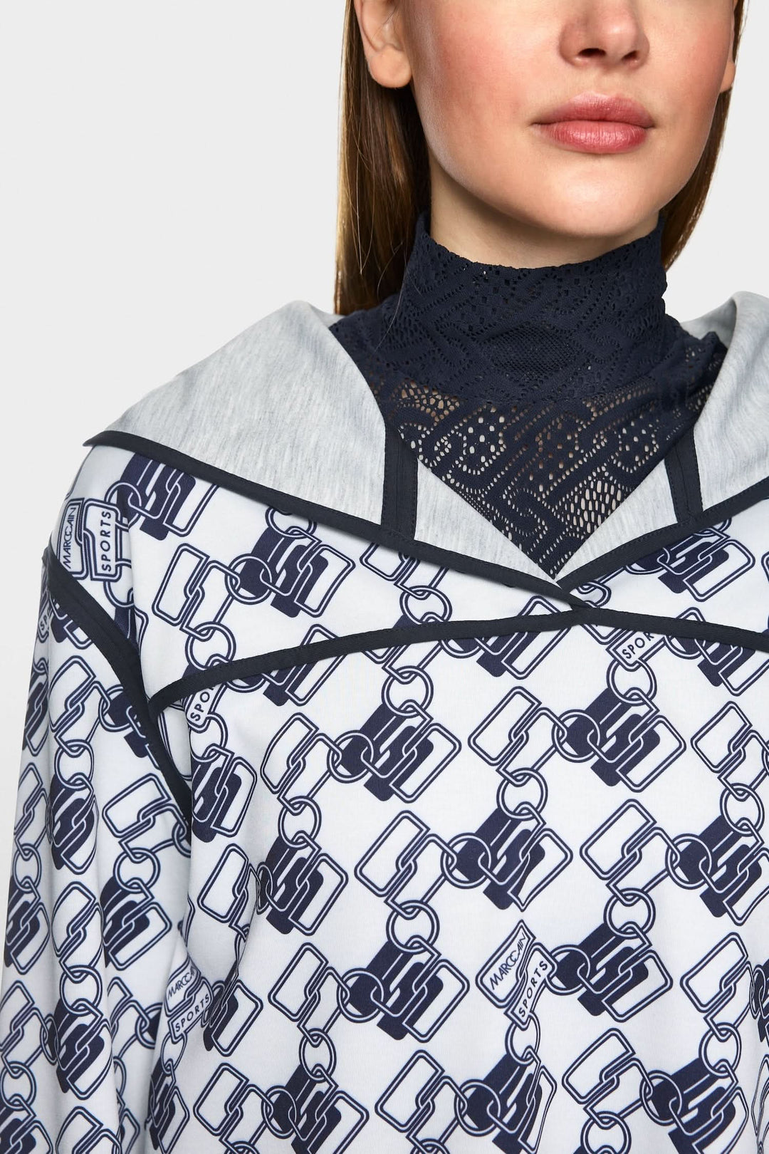 Chandail à capuche réversible avec motif géométrique, coupe ample et fentes latérales, style décontracté.