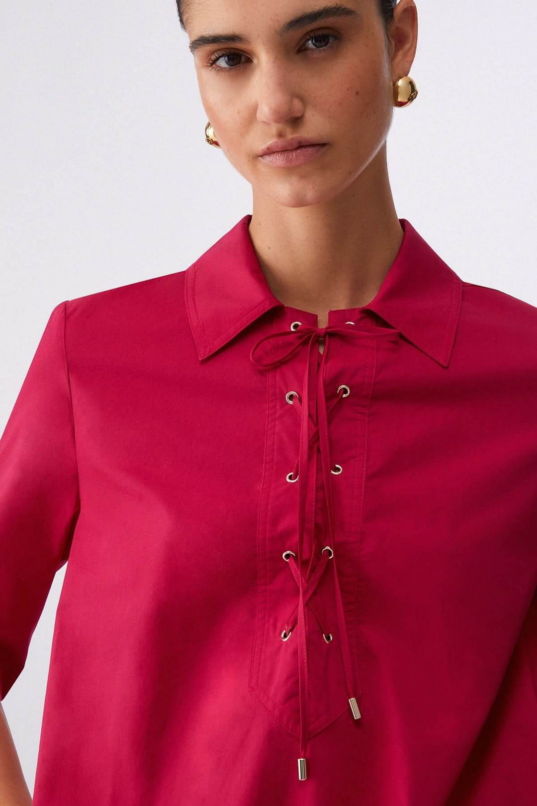 Détail de la robe droite à col chemise lacé en textile rose, montrant les œillets métalliques et le col structuré.